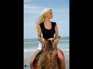 Caylian curtis is sited on a sofa, legs appart and looking at you