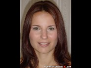 Claudia rossi is sited on a sofa, legs appart and looking at you