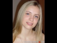 Alissa is sited on a sofa, legs appart and looking at you