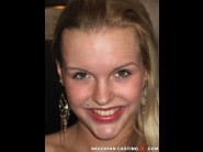 Mia angelo is sited on a sofa, legs appart and looking at you