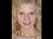 Lucie is sited on a sofa, legs appart and looking at you