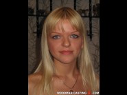 Olga is sited on a sofa, legs appart and looking at you