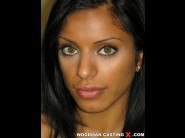 Kira black is sited on a sofa, legs appart and looking at you