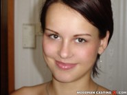 Anna is sited on a sofa, legs appart and looking at you