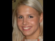 Brandy smile is sited on a sofa, legs appart and looking at you