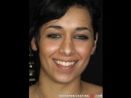 Gabriella is sited on a sofa, legs appart and looking at you