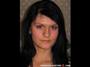 Iyulta is sited on a sofa, legs appart and looking at you