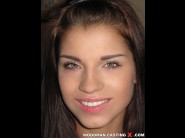 Angel rivas is sited on a sofa, legs appart and looking at you