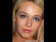 Kitty cat is sited on a sofa, legs appart and looking at you