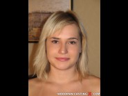 Symone is sited on a sofa, legs appart and looking at you