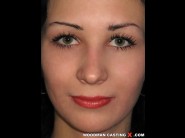 Anna is sited on a sofa, legs appart and looking at you