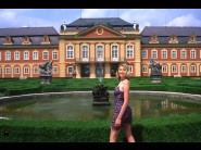 Elsa is sited on a sofa, legs appart and looking at you