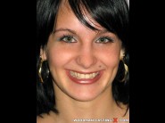 Alexandra is sited on a sofa, legs appart and looking at you