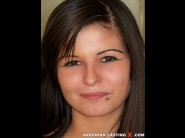 Boglarka is sited on a sofa, legs appart and looking at you