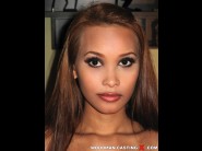 Siri fortuna is sited on a sofa, legs appart and looking at you