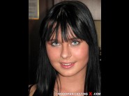 Mia manarote is sited on a sofa, legs appart and looking at you