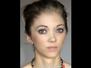 Brandi walner is sited on a sofa, legs appart and looking at you