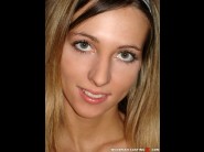 Adrianna is sited on a sofa, legs appart and looking at you