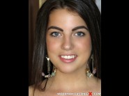 Raven cerna is sited on a sofa, legs appart and looking at you