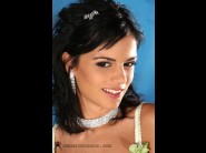 Black angelika is sited on a sofa, legs appart and looking at you