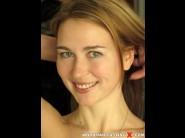 Melisa is sited on a sofa, legs appart and looking at you