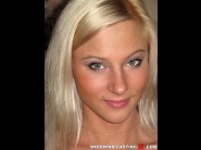 Yekaterina is sited on a sofa, legs appart and looking at you