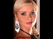 Caylian curtis is sited on a sofa, legs appart and looking at you