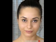 Aurelly rebell is sited on a sofa, legs appart and looking at you