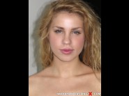 Dominique lips is sited on a sofa, legs appart and looking at you