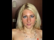 Erika loot is sited on a sofa, legs appart and looking at you