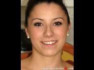 Kitty saint is sited on a sofa, legs appart and looking at you