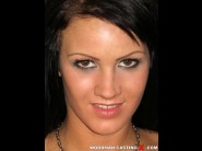 Nia black is sited on a sofa, legs appart and looking at you