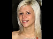 Denni is sited on a sofa, legs appart and looking at you