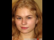 Nisha is sited on a sofa, legs appart and looking at you