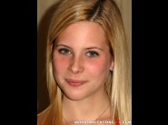 Shyne is sited on a sofa, legs appart and looking at you