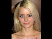 Denisa peterson is sited on a sofa, legs appart and looking at you