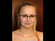 Veronika is sited on a sofa, legs appart and looking at you