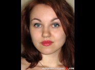 Luba is sited on a sofa, legs appart and looking at you