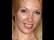 Gina monelli is sited on a sofa, legs appart and looking at you