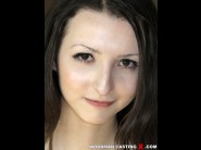 Amy white is sited on a sofa, legs appart and looking at you