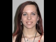 Reka is sited on a sofa, legs appart and looking at you