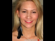 Anitta is sited on a sofa, legs appart and looking at you