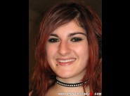 Lilith is sited on a sofa, legs appart and looking at you