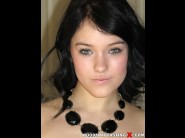 Megan rain is sited on a sofa, legs appart and looking at you