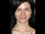 Lina arian is sited on a sofa, legs appart and looking at you