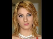 Leona green is sited on a sofa, legs appart and looking at you