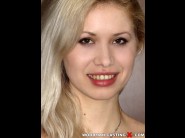 Nicole blond is sited on a sofa, legs appart and looking at you