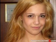 Tereza felaktig is sited on a sofa, legs appart and looking at you