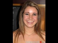 Kinsley eden is sited on a sofa, legs appart and looking at you