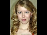 Anna diem is sited on a sofa, legs appart and looking at you